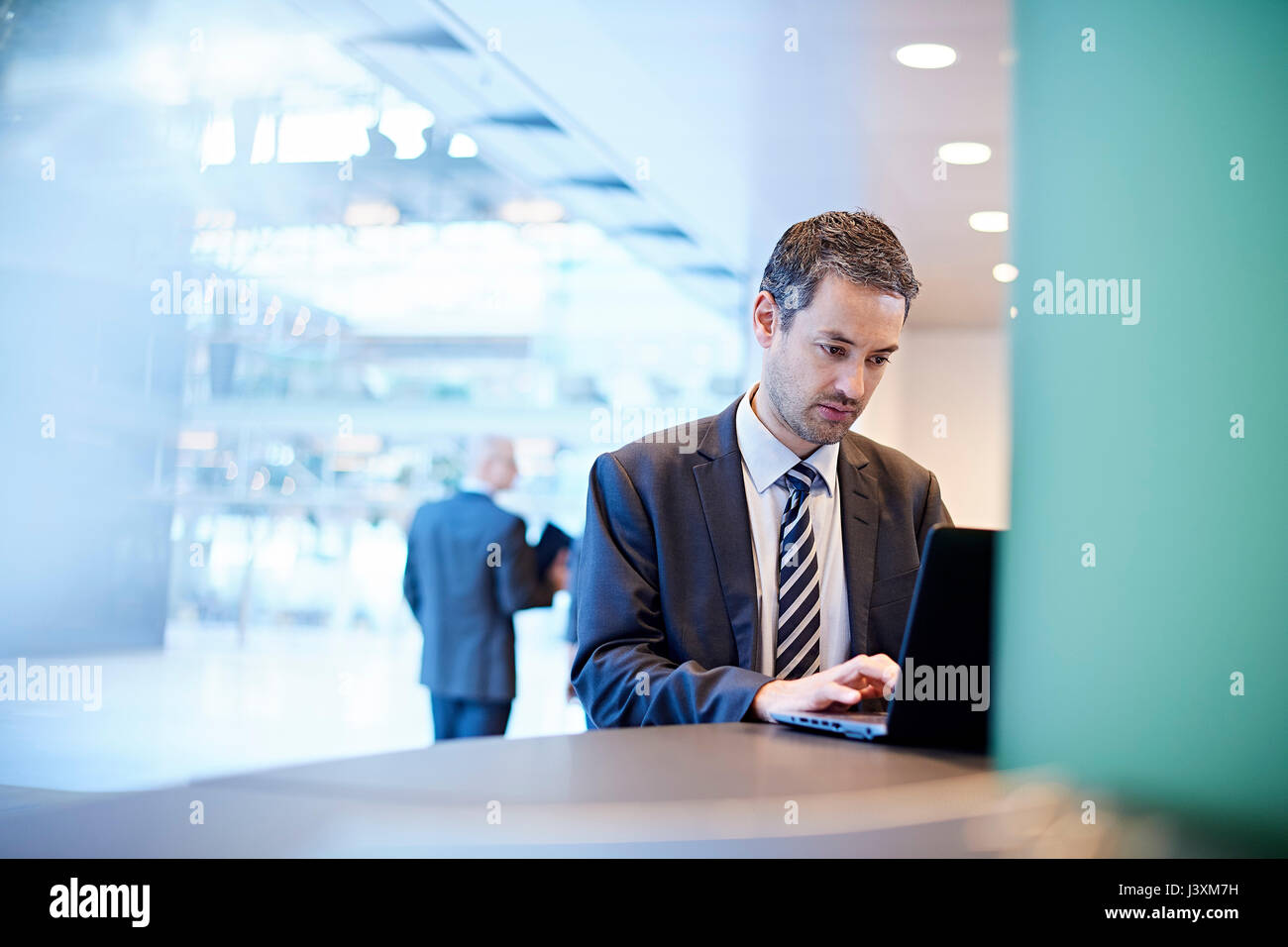 Imprenditore digitazione sul computer portatile in ufficio Foto Stock