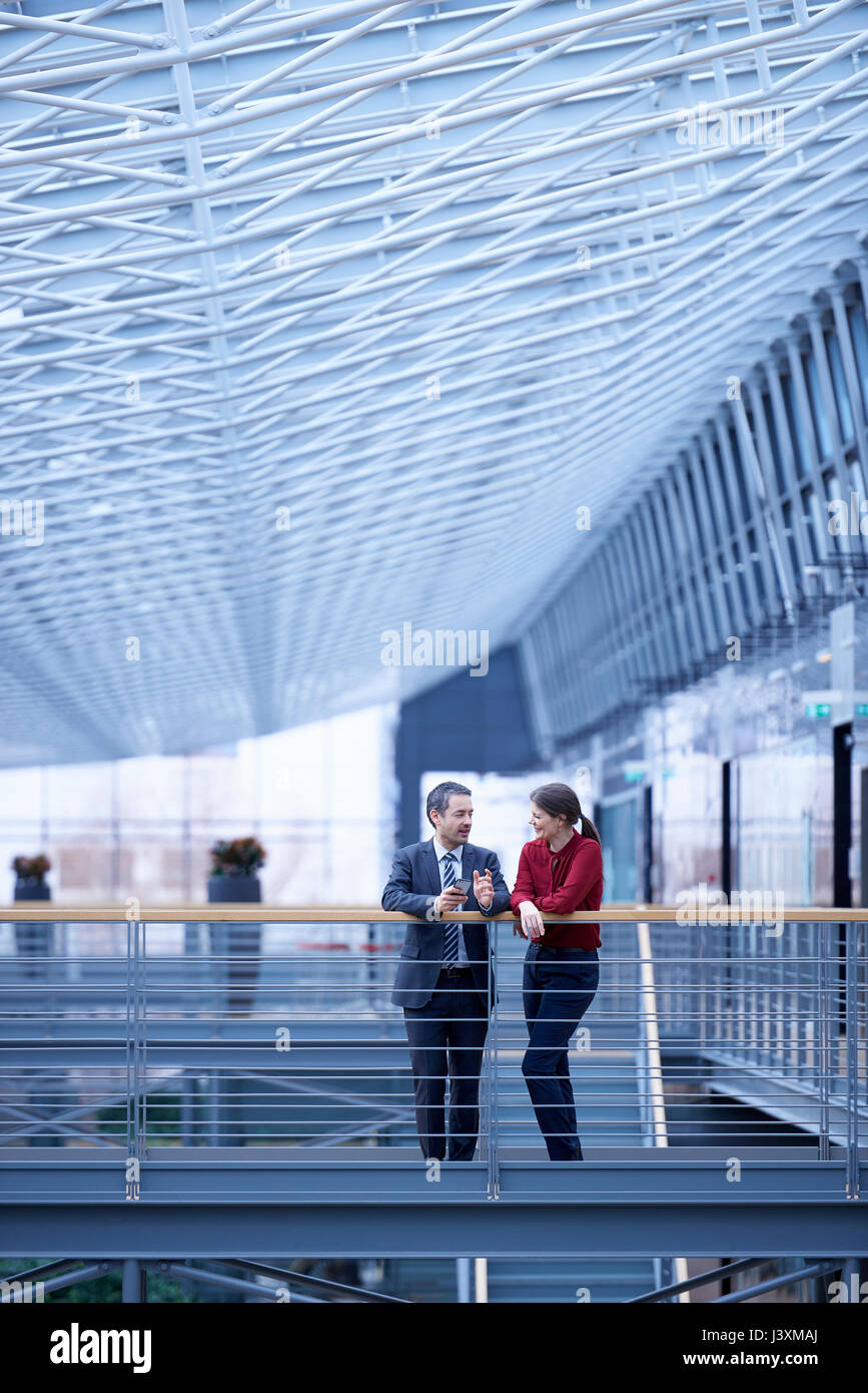 Imprenditore e la donna che parla in office atrium Foto Stock