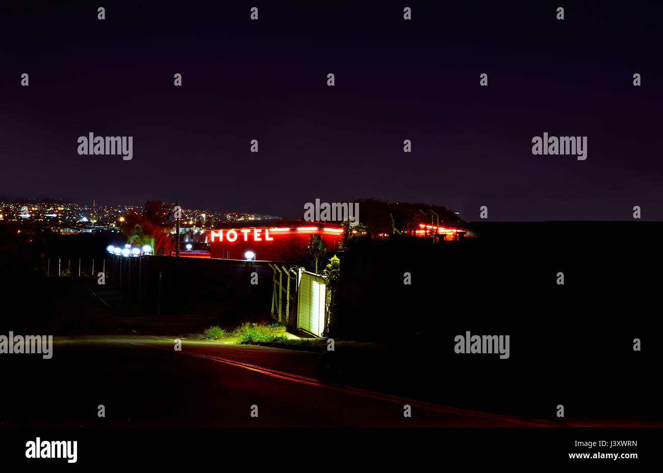 Motel da una secondaria strada scuro con il rosso illuminato sul segno Foto Stock