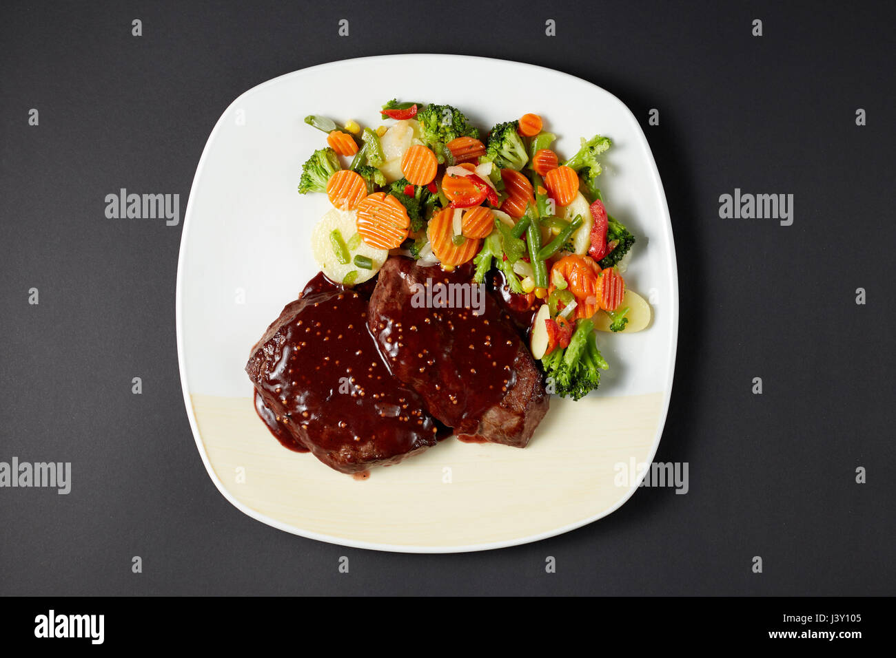 Carni bovine nel vino la salsa di senape. Stile italiano. Il cibo italiano. Cucina Italiana. Studio shot sul buio o sfondo nero. Foto Stock