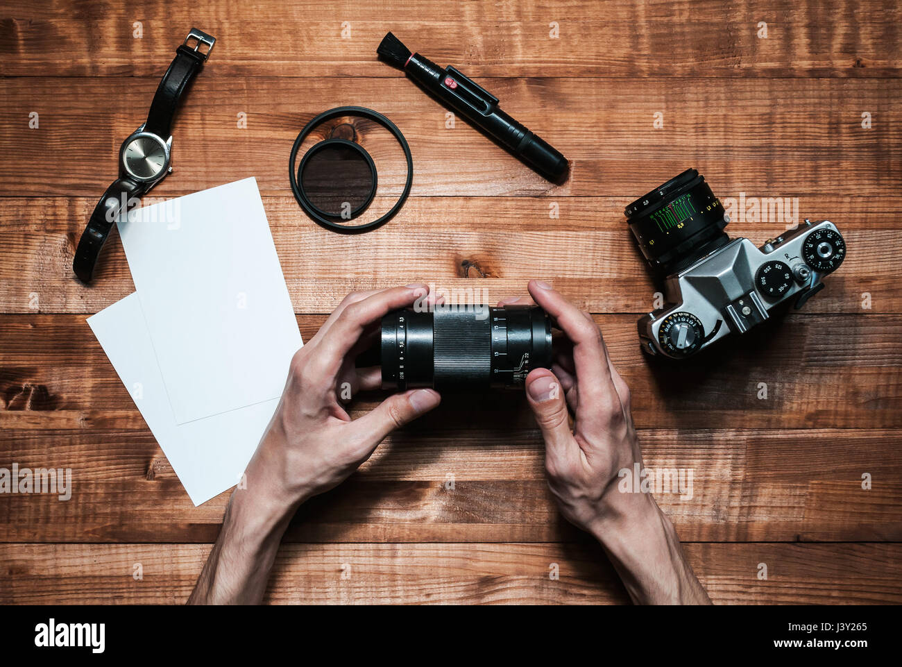 Le mani di un fotografo su un tavolo di legno Foto Stock