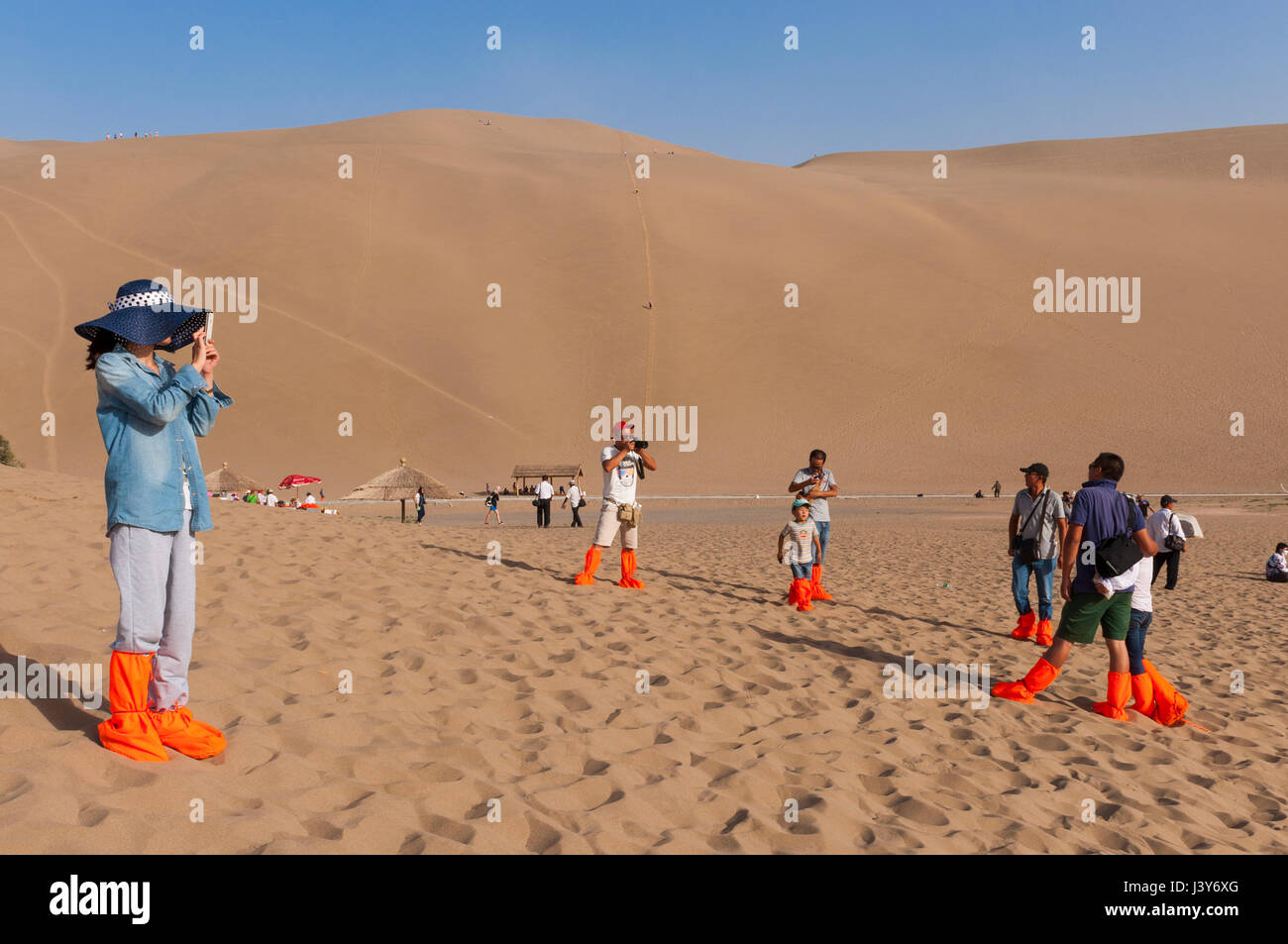 Dunhuang, Cina - 8 Agosto 2012: turisti fotografare nelle dune intorno alla città di Dunhuang, nell'antica Via della Seta, in Cina. Foto Stock