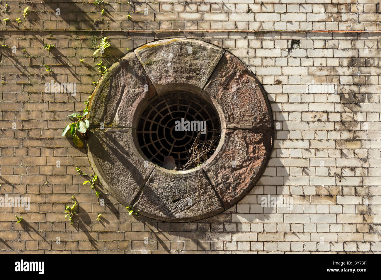 Circolare del foro di ventilazione sul undercroft di scambio ex stazione ferroviaria, Manchester, Inghilterra, Regno Unito Foto Stock