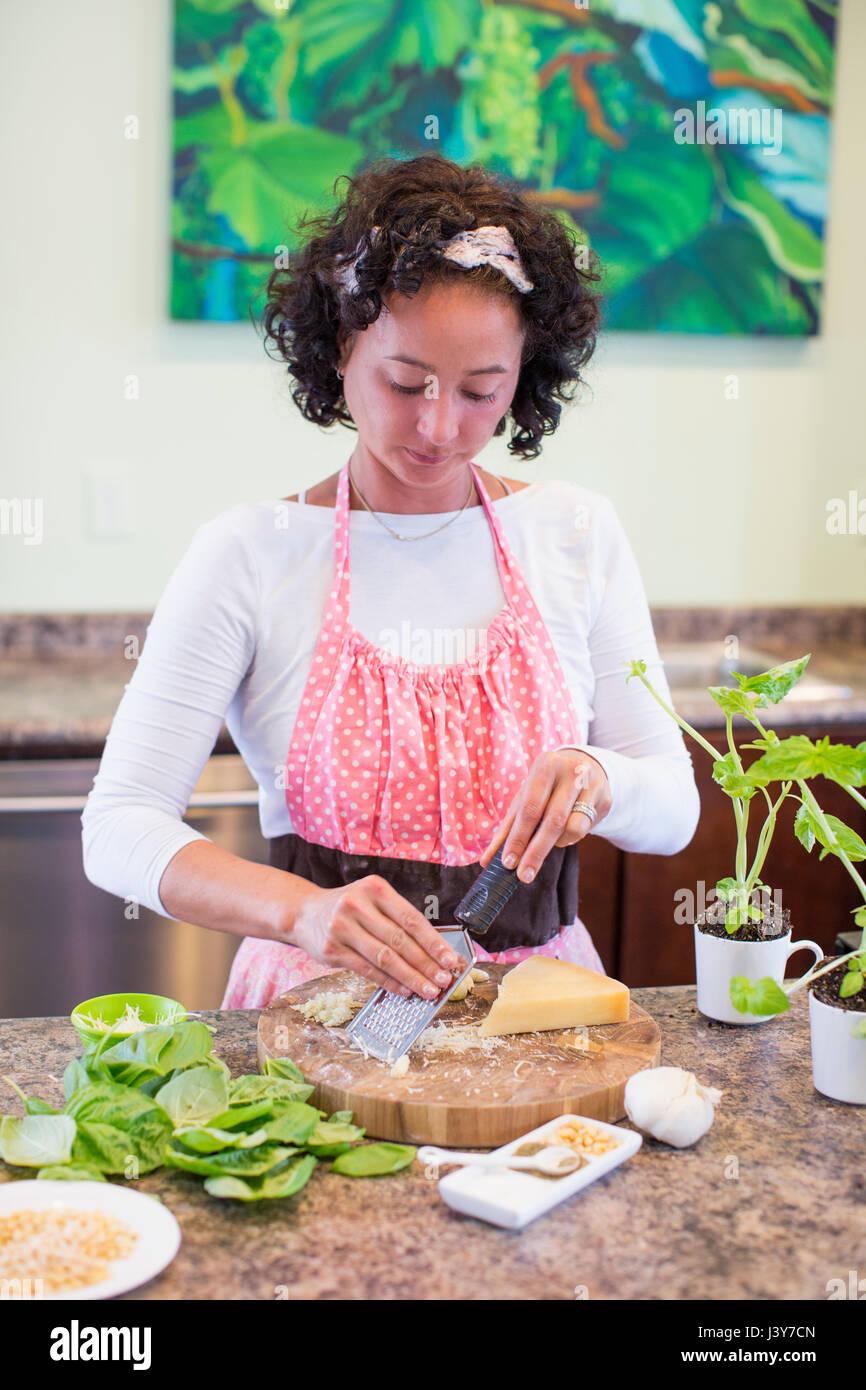 Donna matura grattugiare il formaggio per il pesto ricetta Foto Stock