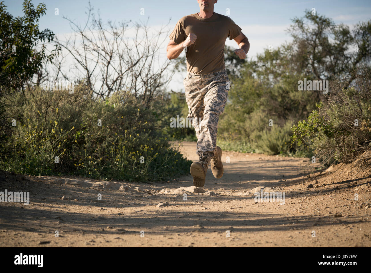 Soldato indossando indumenti di combattimento in esecuzione, Runyon Canyon, Los Angeles, California, Stati Uniti d'America Foto Stock