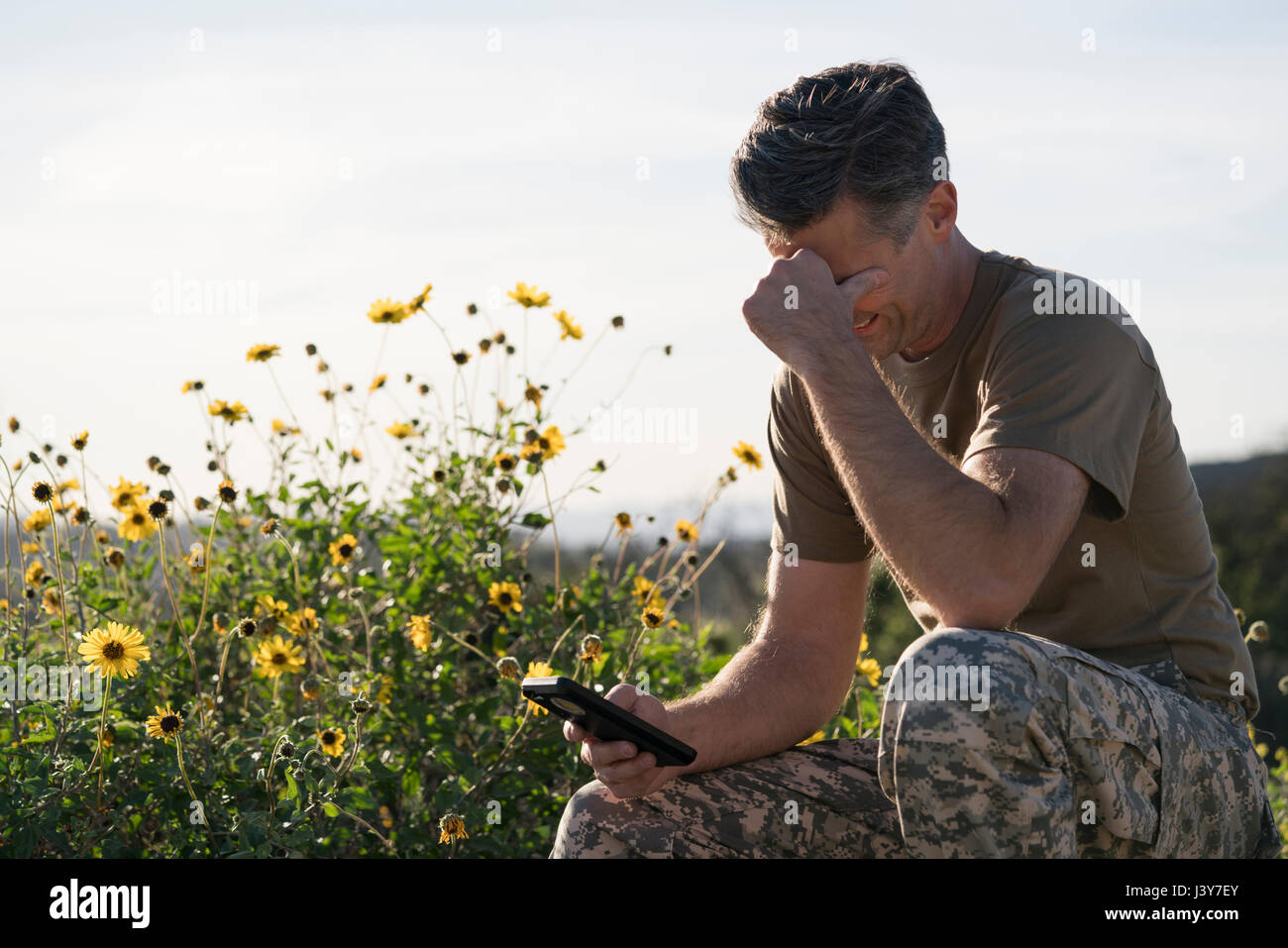 Soldato indossando indumenti di combattimento guardando smartphone, Runyon Canyon, Los Angeles, California, Stati Uniti d'America Foto Stock