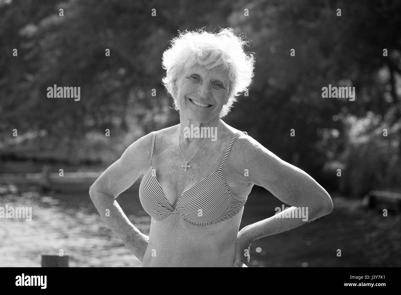 Ritratto di donna senior in bikini guardando sorridente della fotocamera Foto Stock