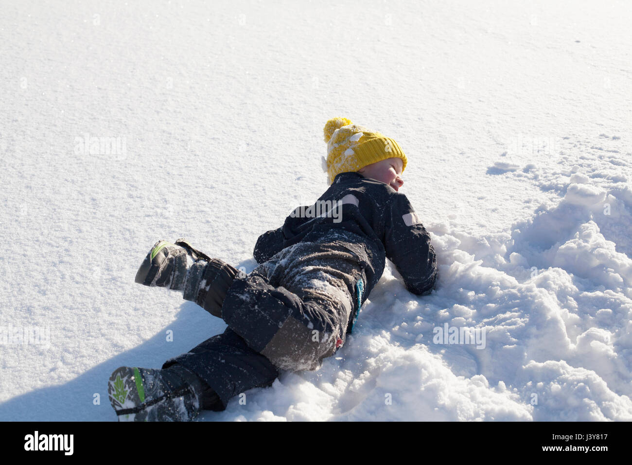 Ragazzo giovane ingannare intorno nella neve Foto Stock