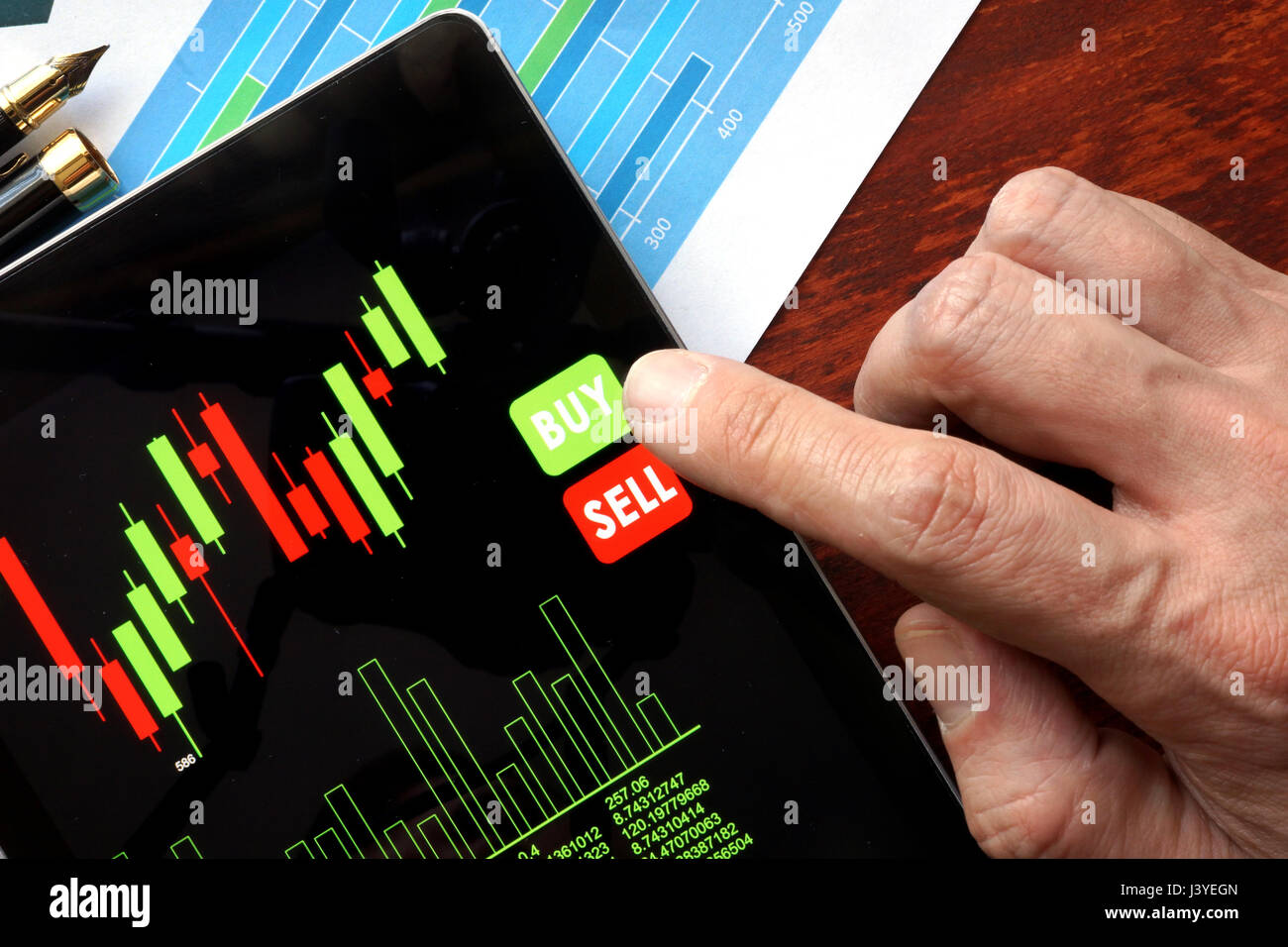 Il trading online concetto. Tablet con la finanziaria i dati di stock e dito. Foto Stock