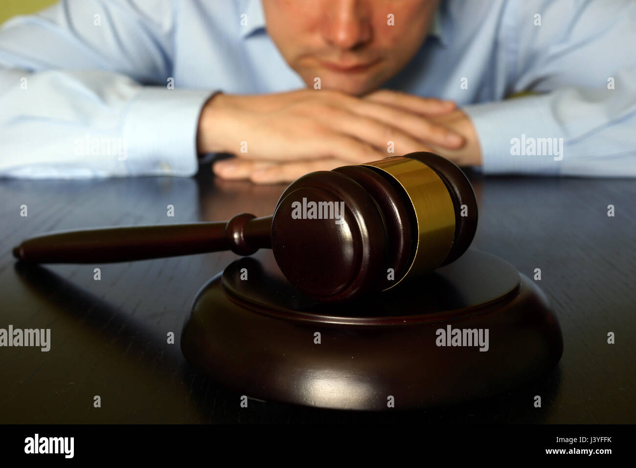 Concetto di giustizia. L uomo è seduta al tavolo di fronte martello. Foto Stock