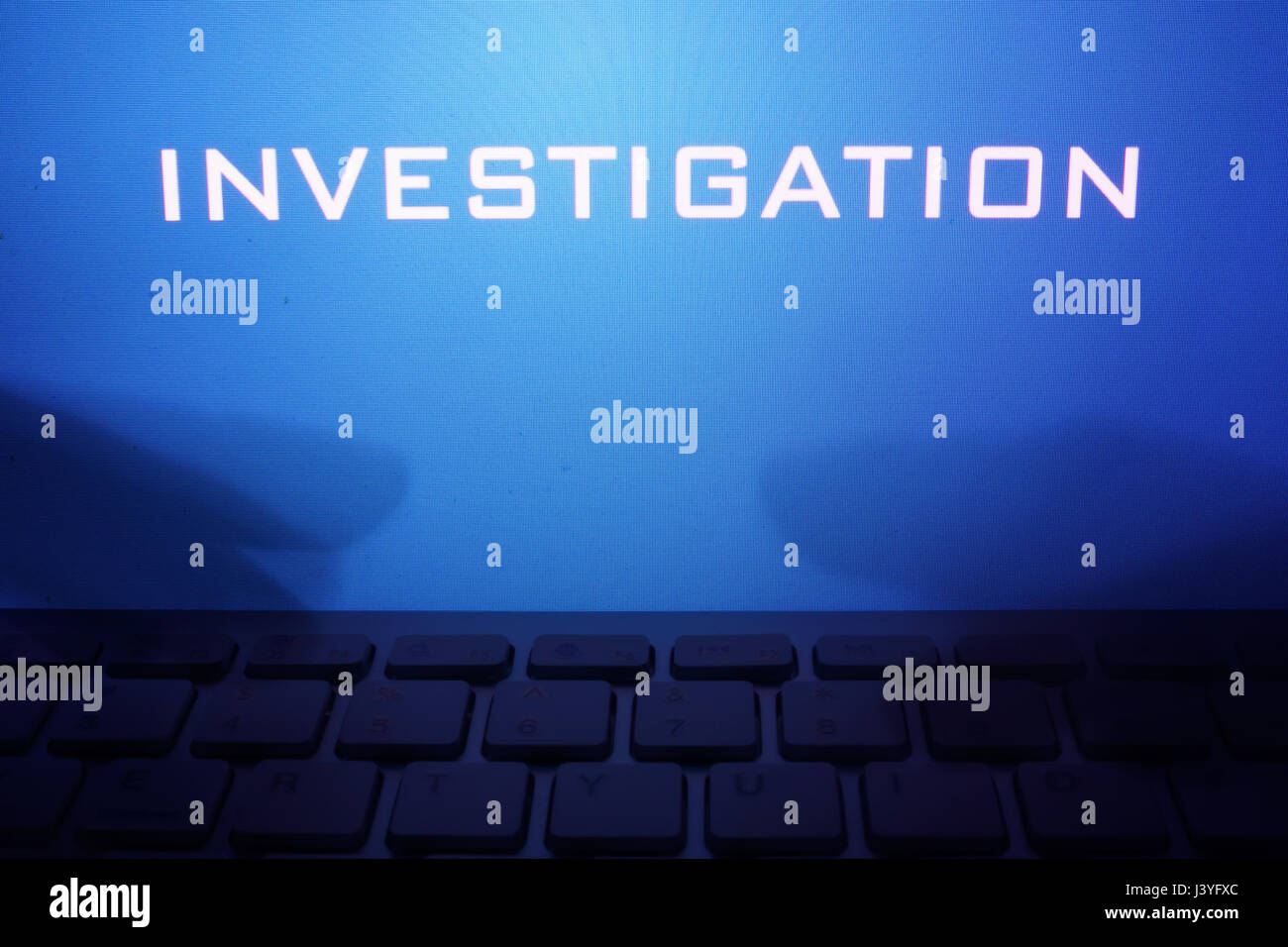 Monitor con messaggio di indagine e le mani su una tastiera. Foto Stock