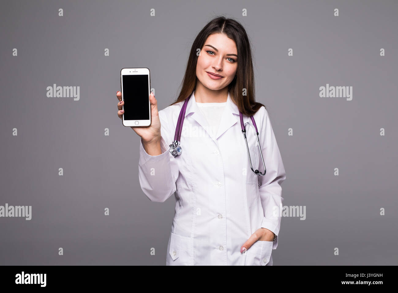Giovane medico donna puntando sul cellulare schermo Foto Stock