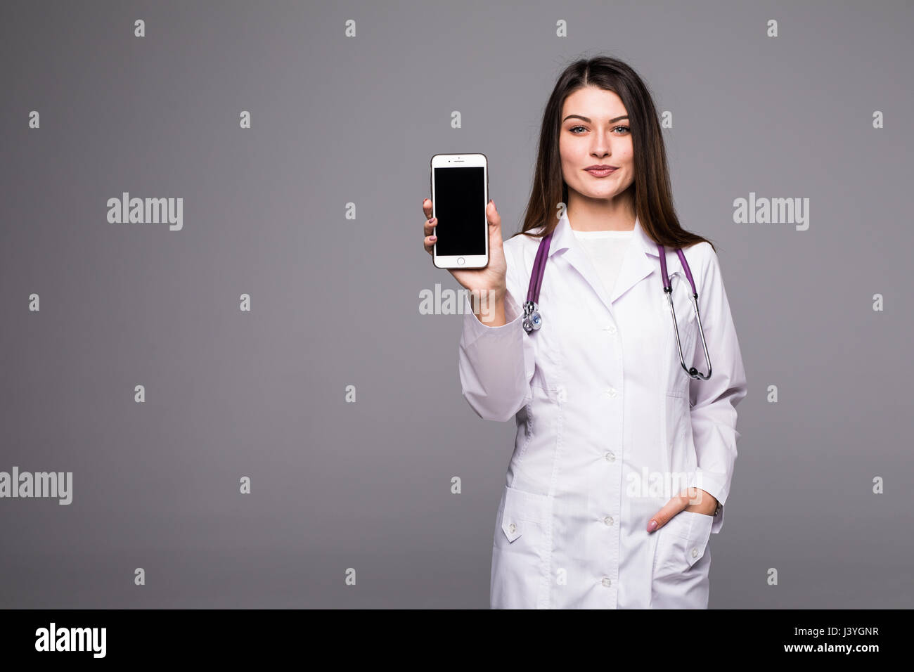 Giovane medico donna puntando sul cellulare schermo Foto Stock