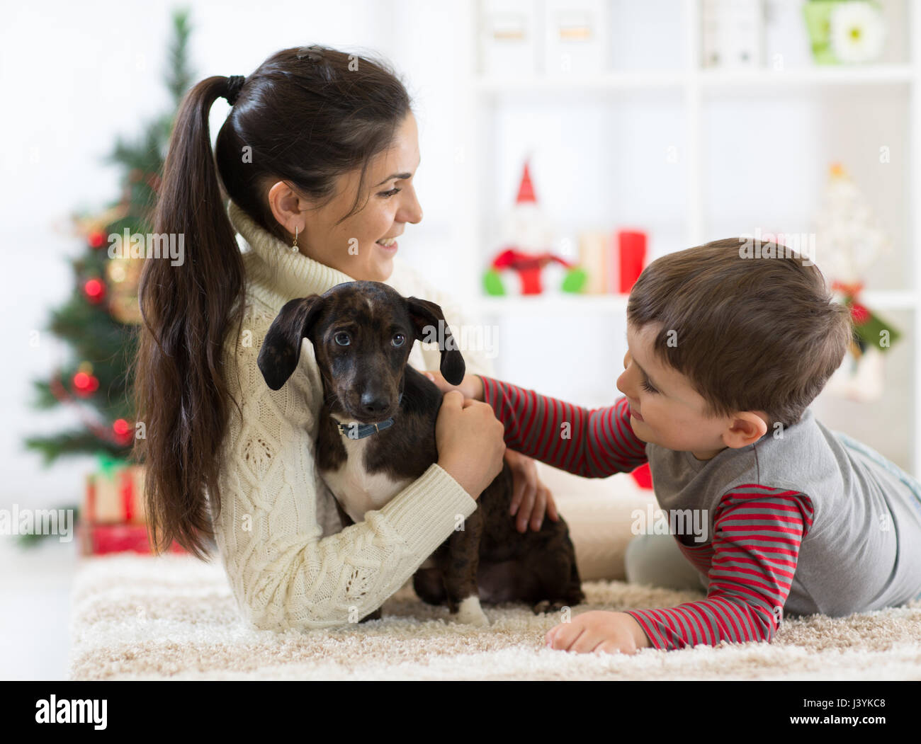 Happy little boy, sua madre e il cane a Natale Foto Stock