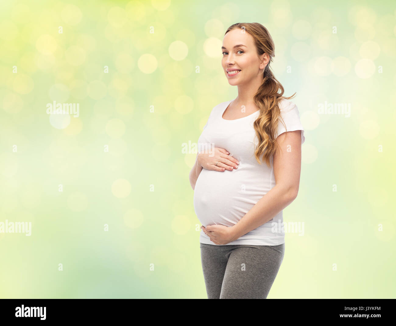 Felice donna incinta di toccare la sua grande pancia Foto Stock