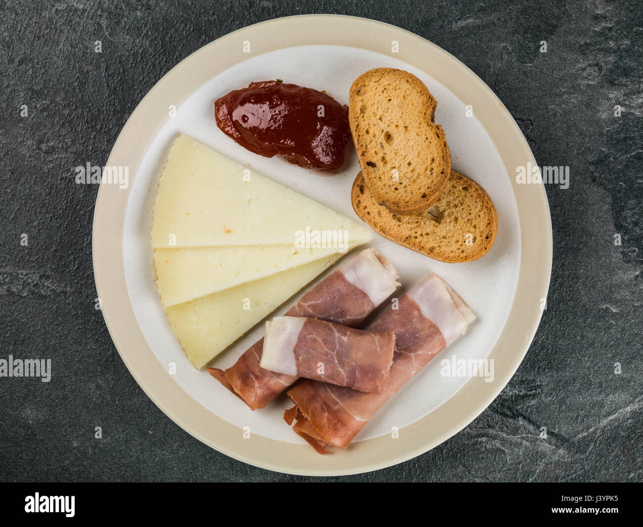 Selezione di tapas con chutney di pomodoro su un nero Sfondo piastrelle Foto Stock