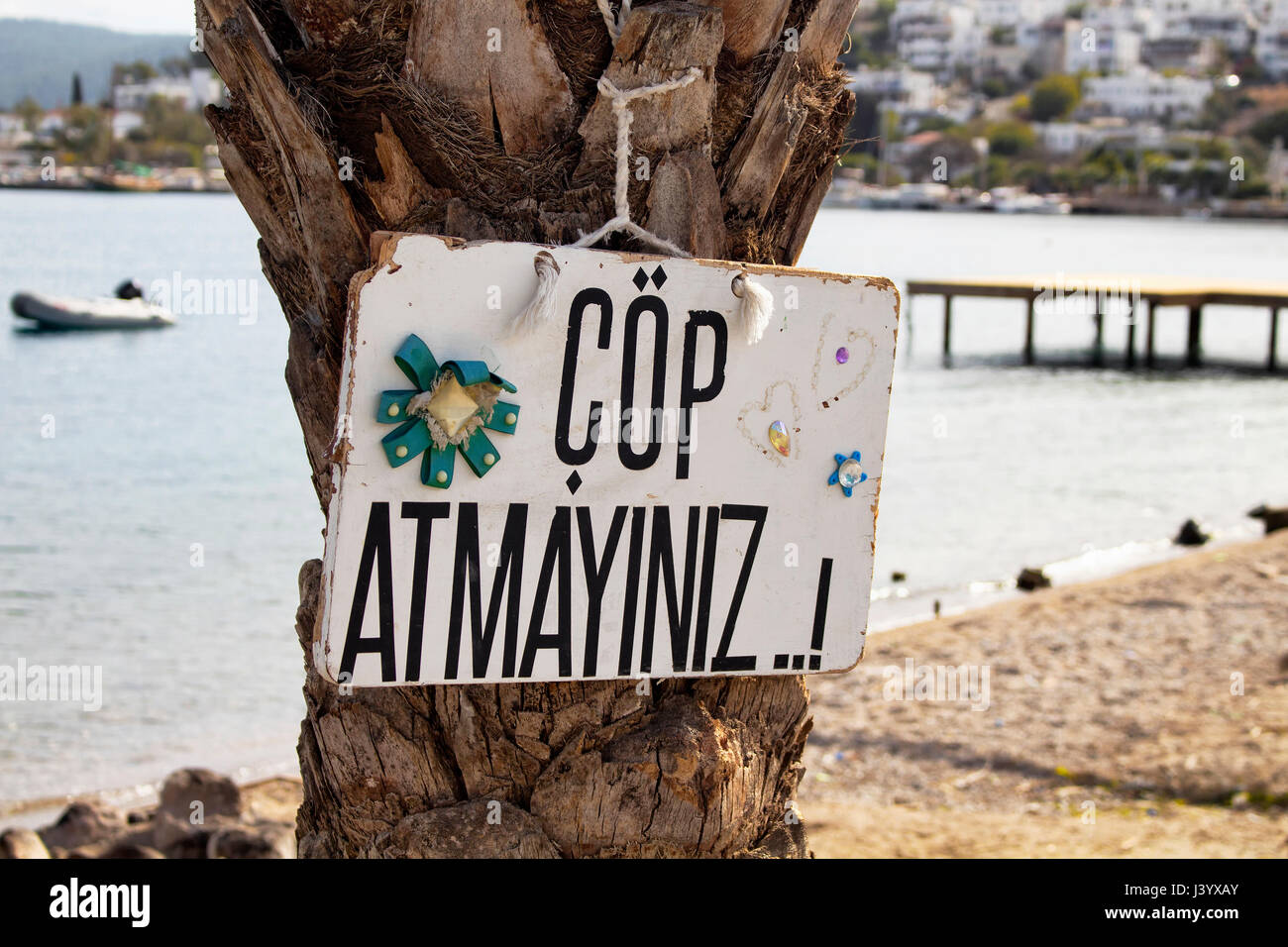 Una segnaletica in legno di 'Cop Atmayiniz' significa 'non figliata' in turco in una spiaggia nel villaggio di Turkbuku nella penisola di Bodrum, situato nella parte sud-ovest Turke Foto Stock