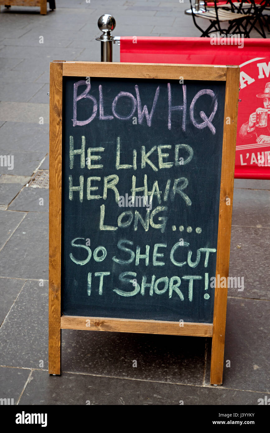 Un segno che si legge, "egli amava molto i suoi capelli lunghi . . . Quindi ha tagliato corto!", al di fuori di un nail bar su Cockburn Street, Edimburgo, Scozia, Regno Unito. Foto Stock