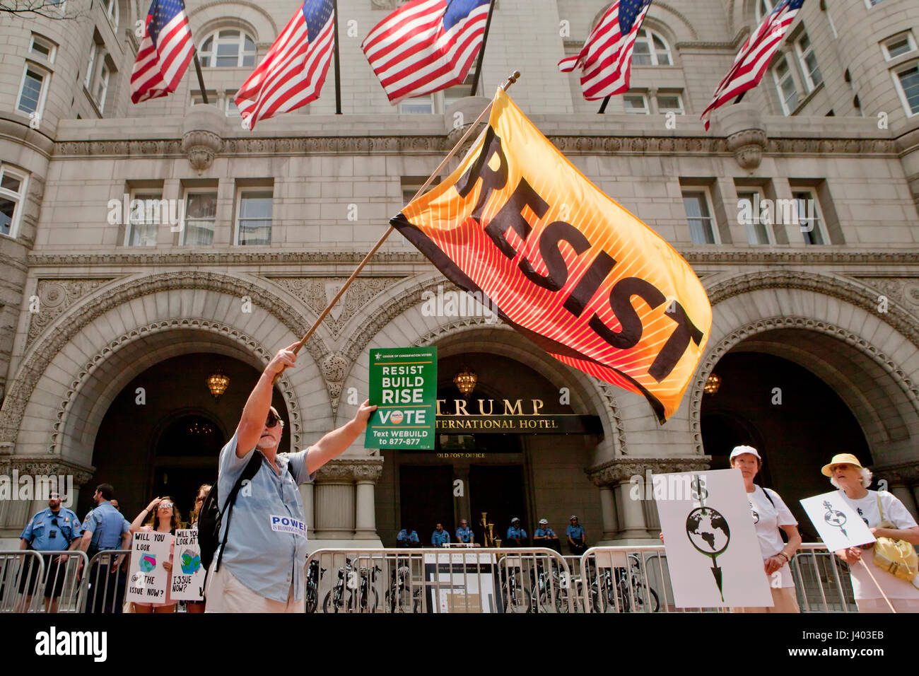 Il cambiamento climatico attivista sventola bandiera di resist di fronte Trump International Hotel - Washington DC, Stati Uniti d'America Foto Stock