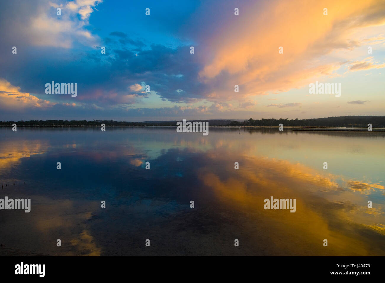 Ci è qualcosa circa il mistico cloud riflessioni ancora in acqua. I colori e le forme delle nuvole sono accentuati in questo tranquillo tramonto. Foto Stock