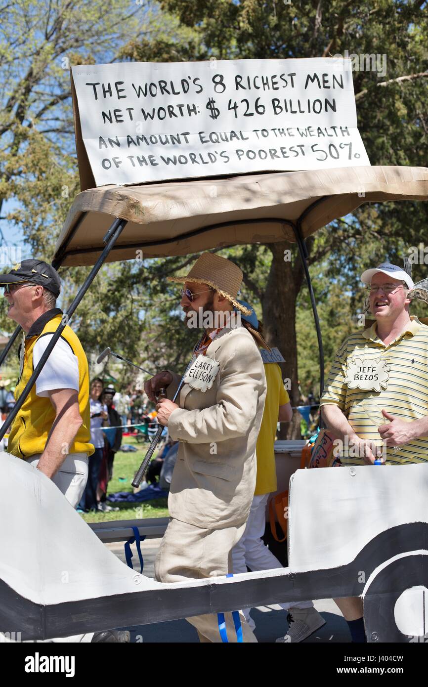 Un valore a virgola mobile che rappresenta il mondo 8 uomini più ricchi e la protesta della iniqua distribuzione della ricchezza, presso la Mayday parade di Minneapolis, Minnesota, Stati Uniti d'America. Foto Stock