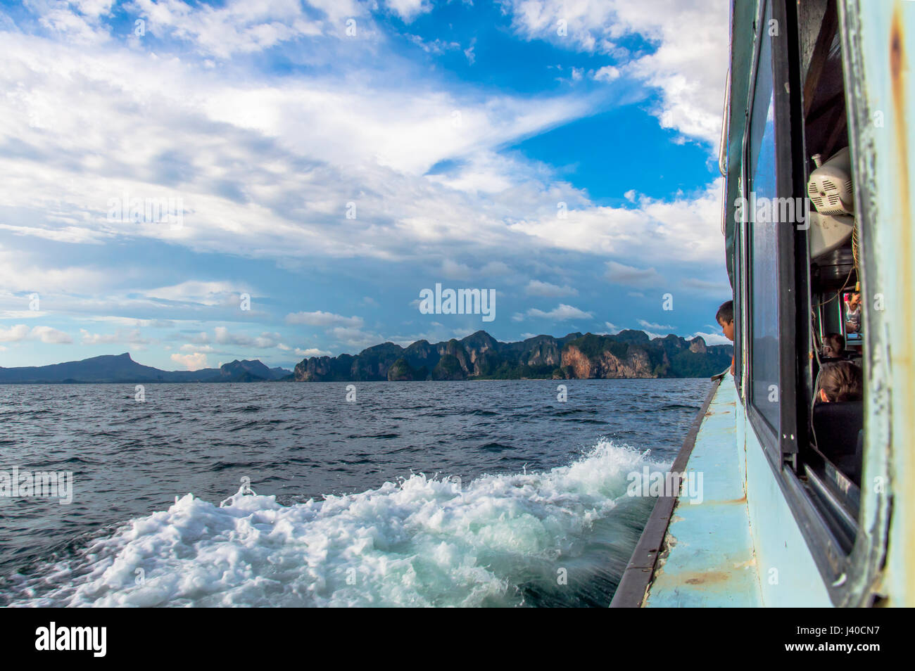 Vista laterale del traghetto contro la vela isola Costa e nuvole Foto Stock