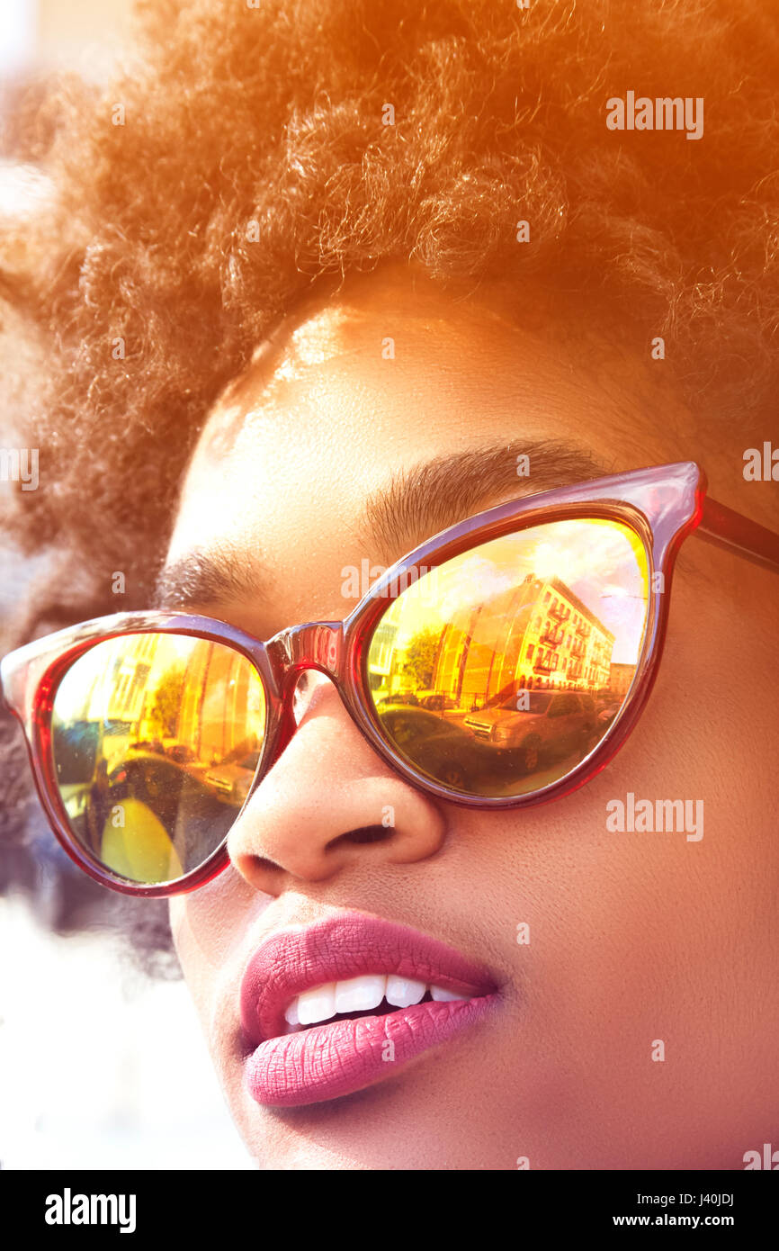 Close up ritratto di giovane donna fashion blogger con capelli afro e occhiali da sole con mirroring, New York, Stati Uniti d'America Foto Stock