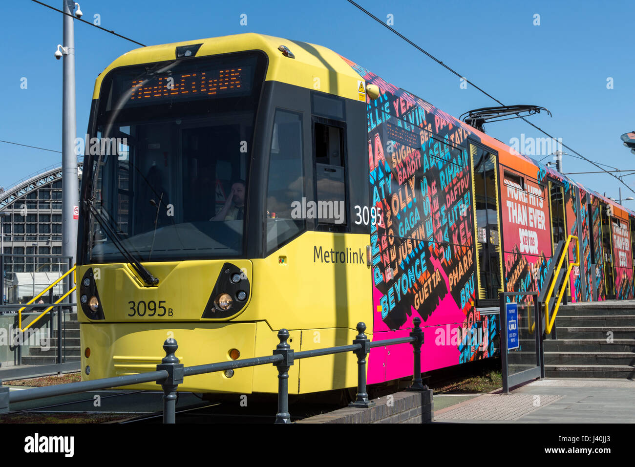 Tram Metrolink con pubblicità la copertura in vinile al Deansgate-Castlefield fermata del tram, Manchester, Inghilterra, Regno Unito Foto Stock