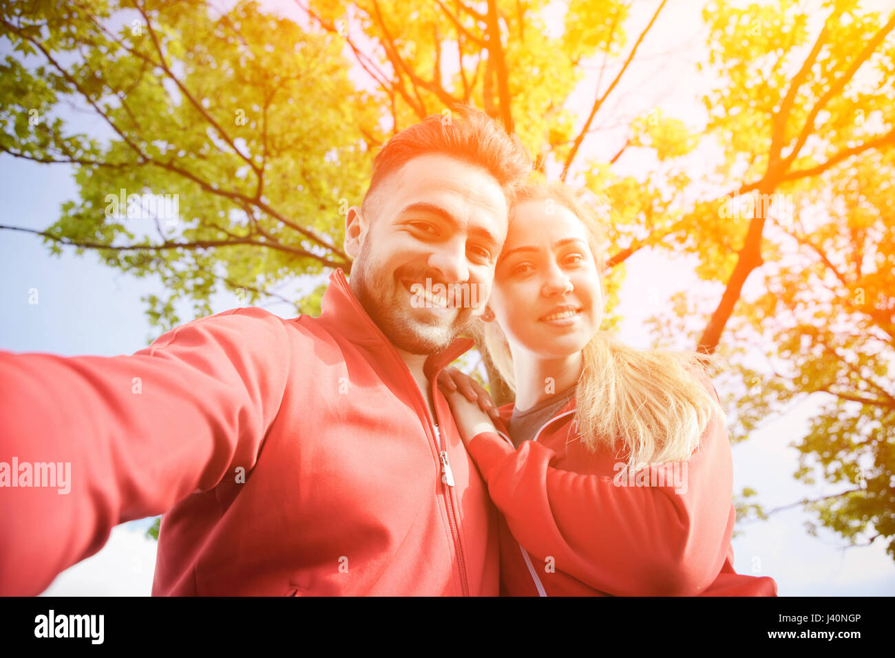 Sport l uomo e la donna che fa selfies in posizione di parcheggio Foto Stock