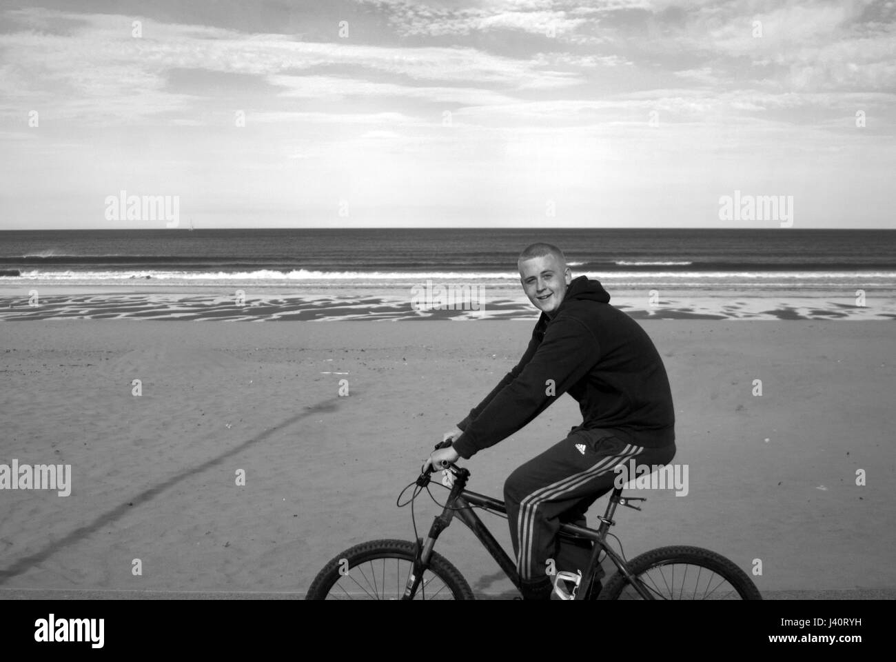 Ragazzo e bici a South Shields beach Foto Stock