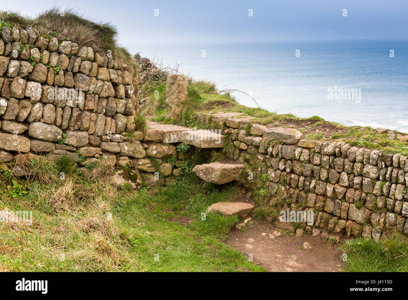 Una fase di stile in una pietra a secco muro costruito da blocchi di granito di diverse dimensioni e colori a Cape Cornwall, Cornwall, Regno Unito Foto Stock