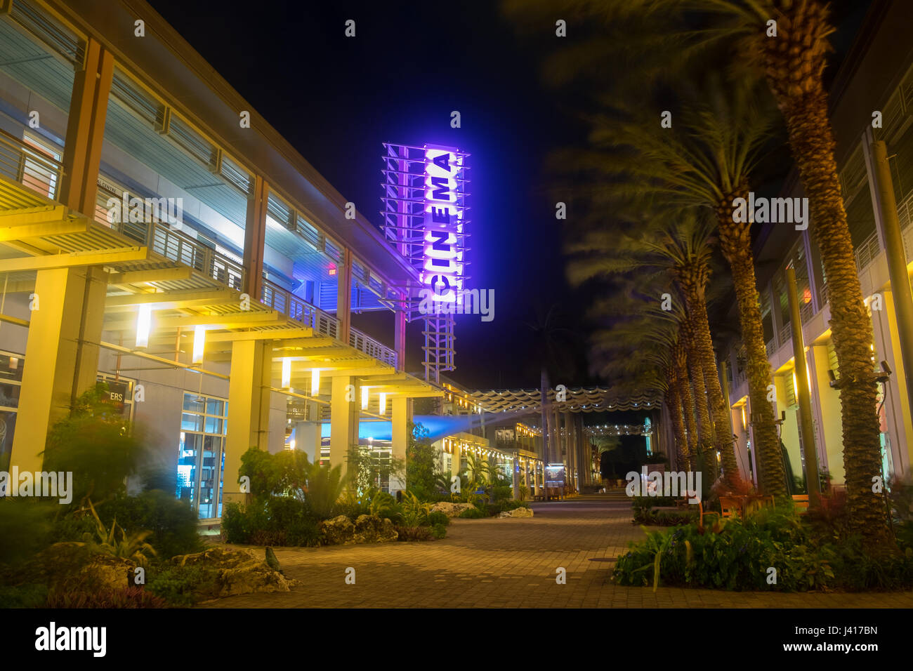 Grand Cayman, Isole Cayman, cinema insegna al neon in una strada pedonale nelle ore notturne in Camana Bay una moderna città sul lungomare nella regione dei Caraibi Foto Stock