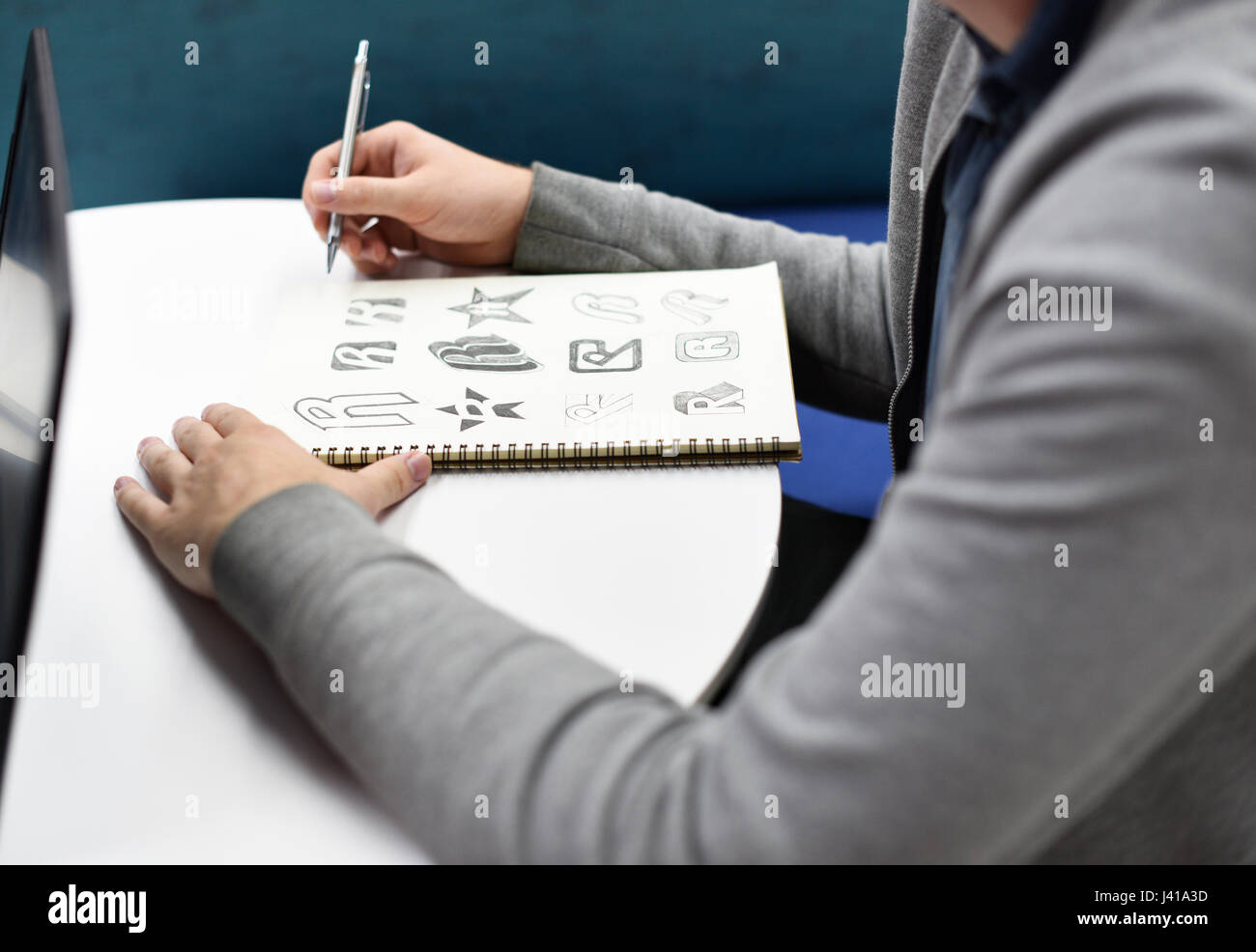 Mano che tiene il notebook con disegnò il Logo del marchio Creative Idee di Design Foto Stock