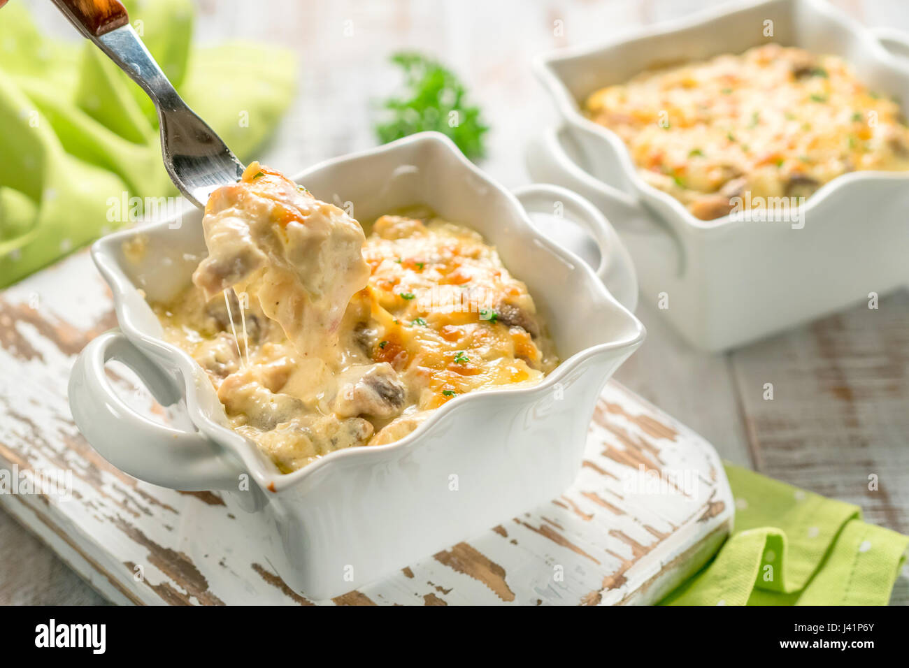 Gratinati al forno pollo in casseruola con funghi in salsa alla panna con formaggio Foto Stock
