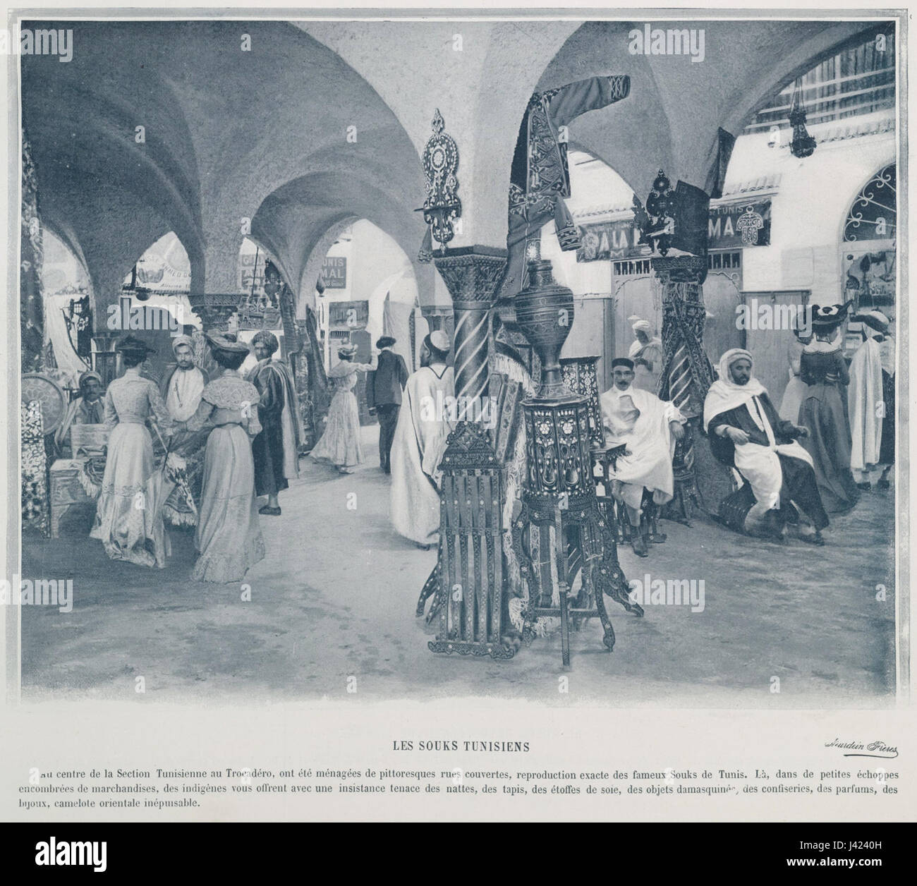 "Les souks tunisiens" si riferisce ai mercati tunisini presentati all'esposizione Universelle del 1900 a Parigi. Questi mercati mostravano l'artigianato tradizionale tunisino, i tessuti e le merci, offrendo uno sguardo sulla cultura nordafricana durante i primi anni del XX secolo. L'esposizione ha evidenziato la diversità culturale delle regioni mostrate. Foto Stock