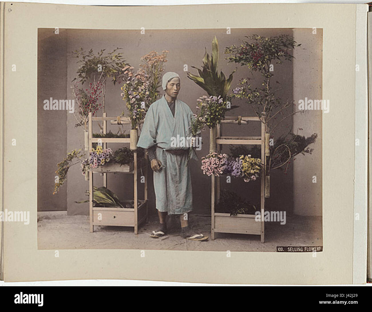Questa fotografia di Kusakabe Kimbei cattura una scena di vendita di fiori in Giappone durante la fine del XIX secolo. L'immagine mostra la tradizionale vita di strada giapponese e il significato culturale dei fiori nella società giapponese. Foto Stock