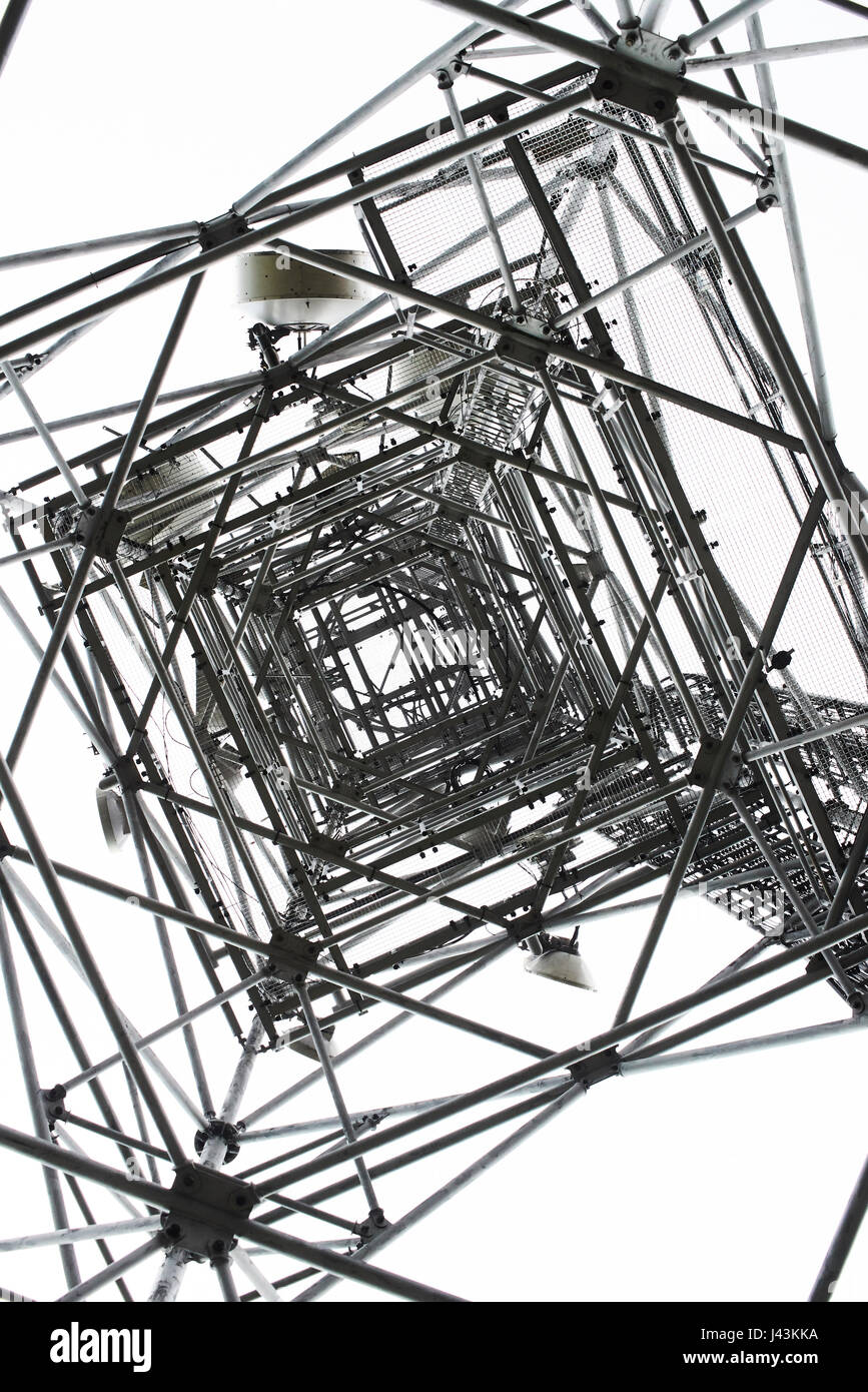 Torre di comunicazione su sfondo bianco. Vista dal basso Foto Stock