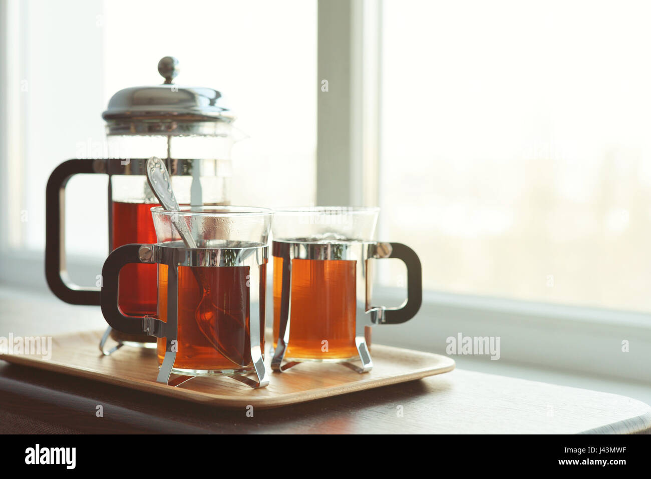 Tazze di tè con french press e limone sul divano nel soggiorno closeup. Foto Stock