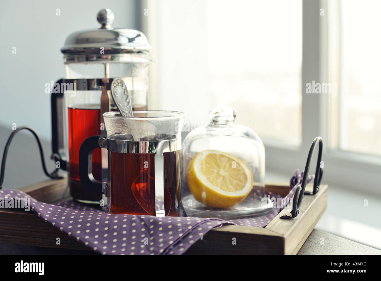 Tazze di tè su vintage vassoio con french press sul divano closeup. Foto Stock