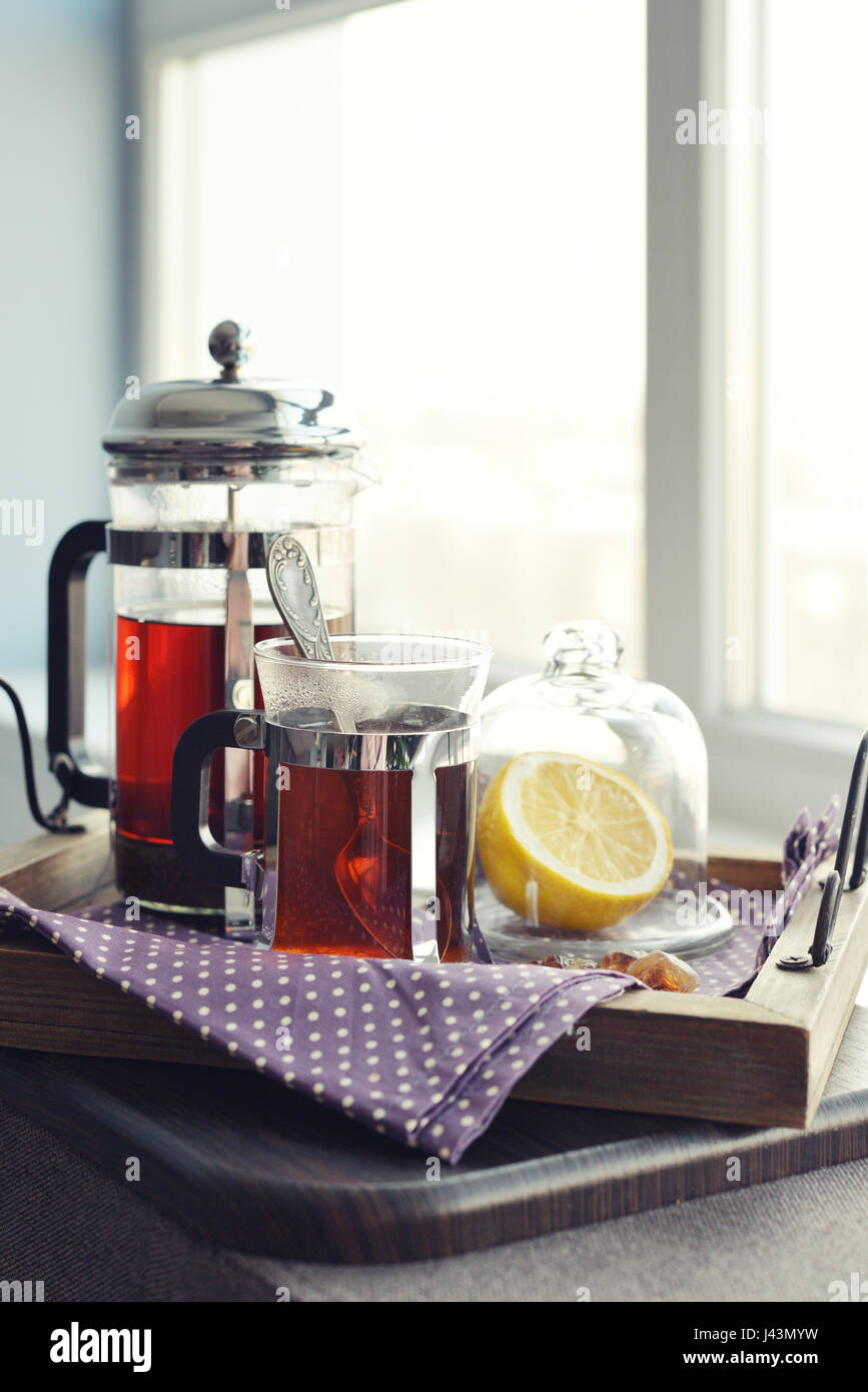 Tazze di tè con french press e limone sul divano nel soggiorno closeup. Foto Stock