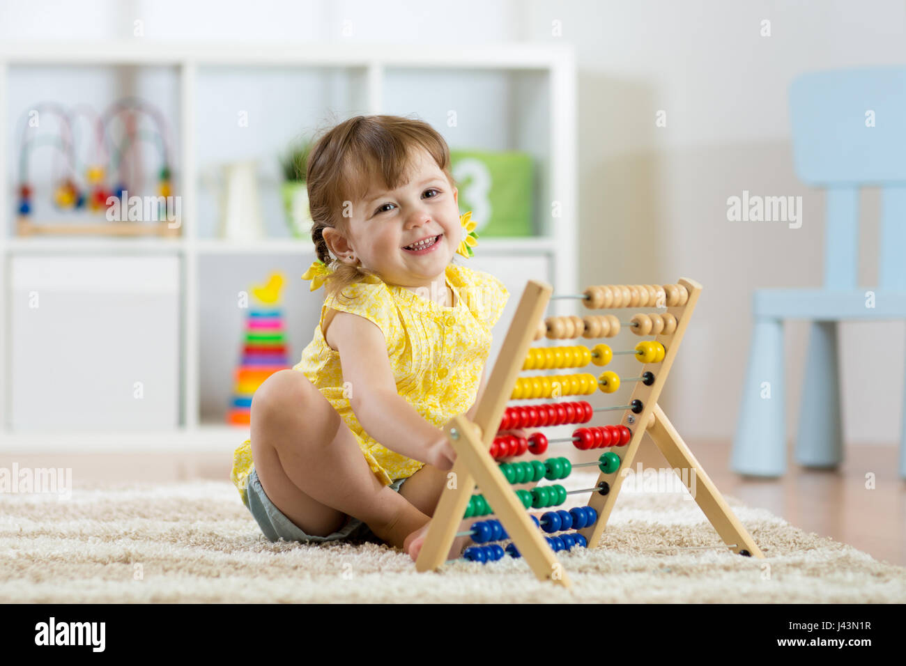 Capretto sorridente ragazza che gioca con il giocattolo del contatore Foto Stock