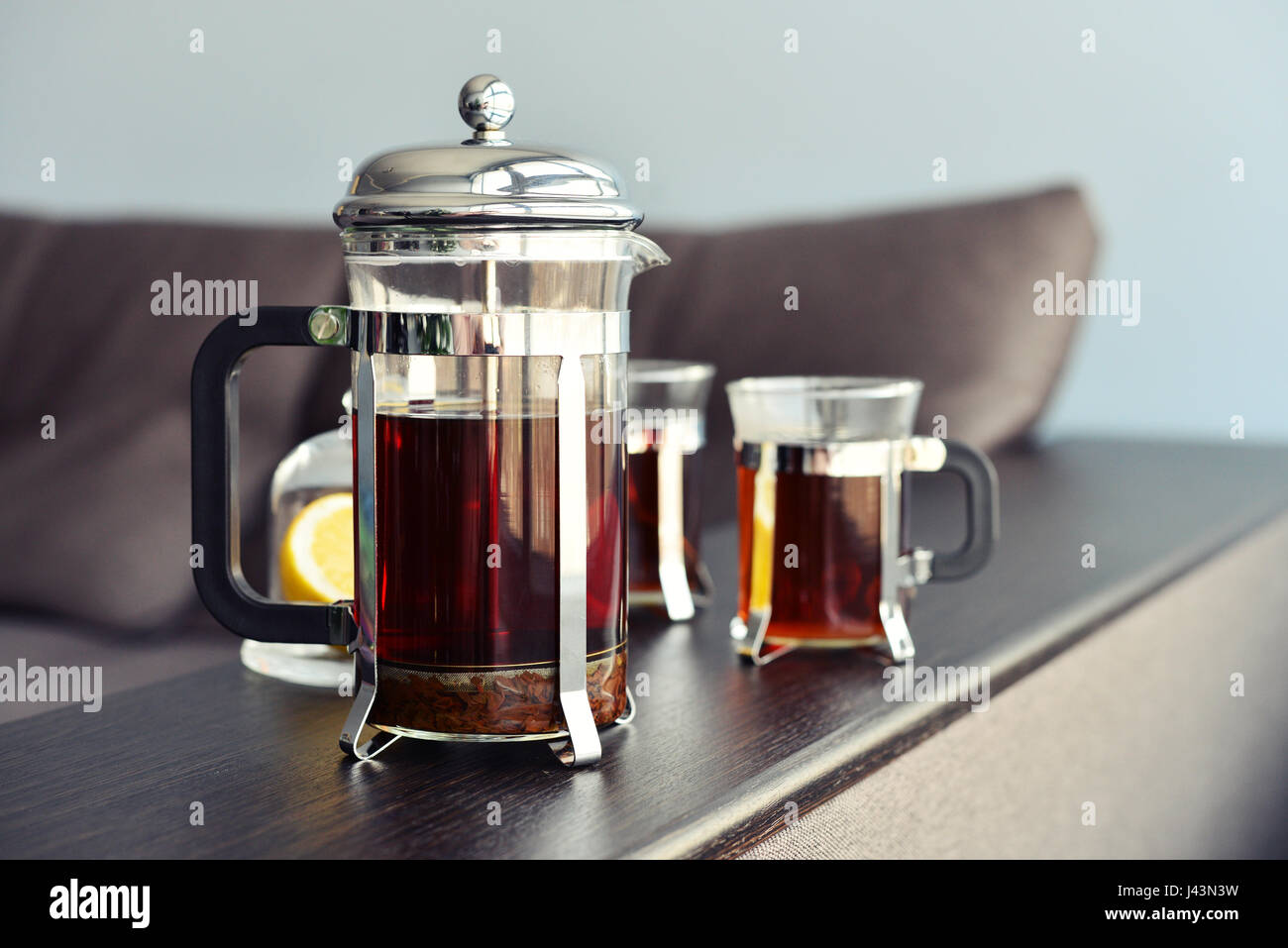 Tazze di tè con french press sul divano closeup. Foto Stock