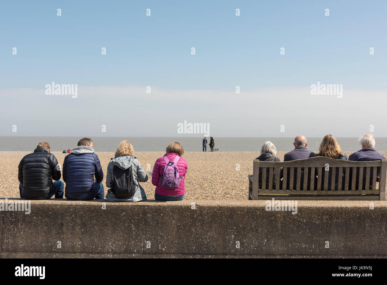 La gente seduta sulla spiaggia a mangiare pesce e patatine a Aldeburgh Suffolk REGNO UNITO Foto Stock