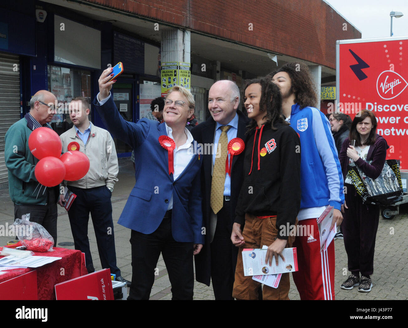Eddie Izzard (sinistra) e candidato del lavoro Jack Dromey (centro) posa per una selfie durante la campagna elettorale in Erdington High Street, Birmingham. Foto Stock
