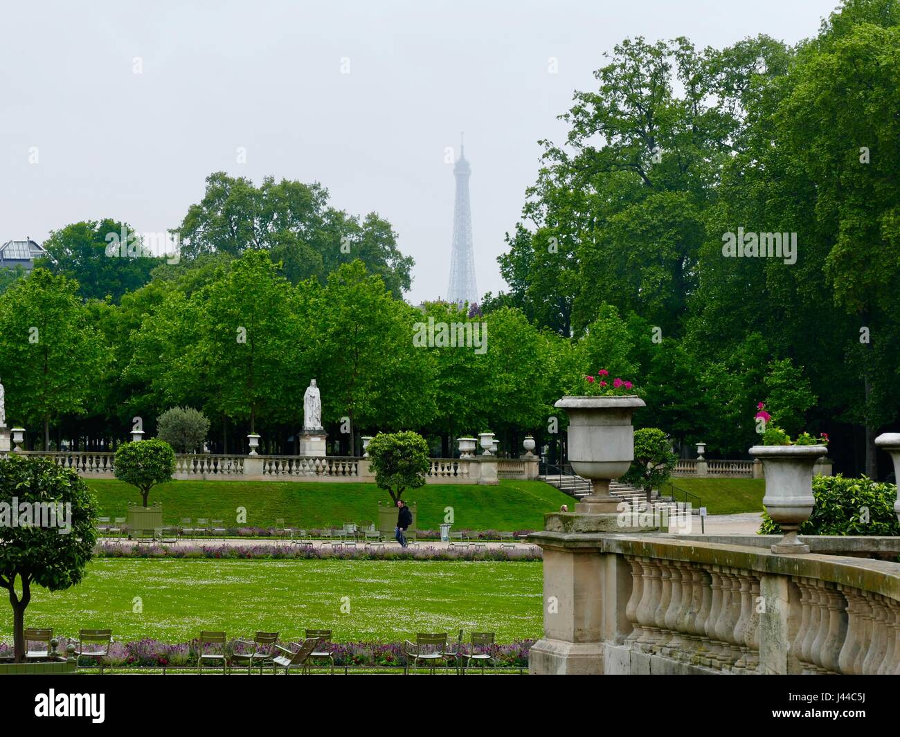 Torre Eiffel visto quasi in silhouette attraverso le nuvole. Giorno di pioggia nei giardini di Lussemburgo. Parigi, Francia Foto Stock