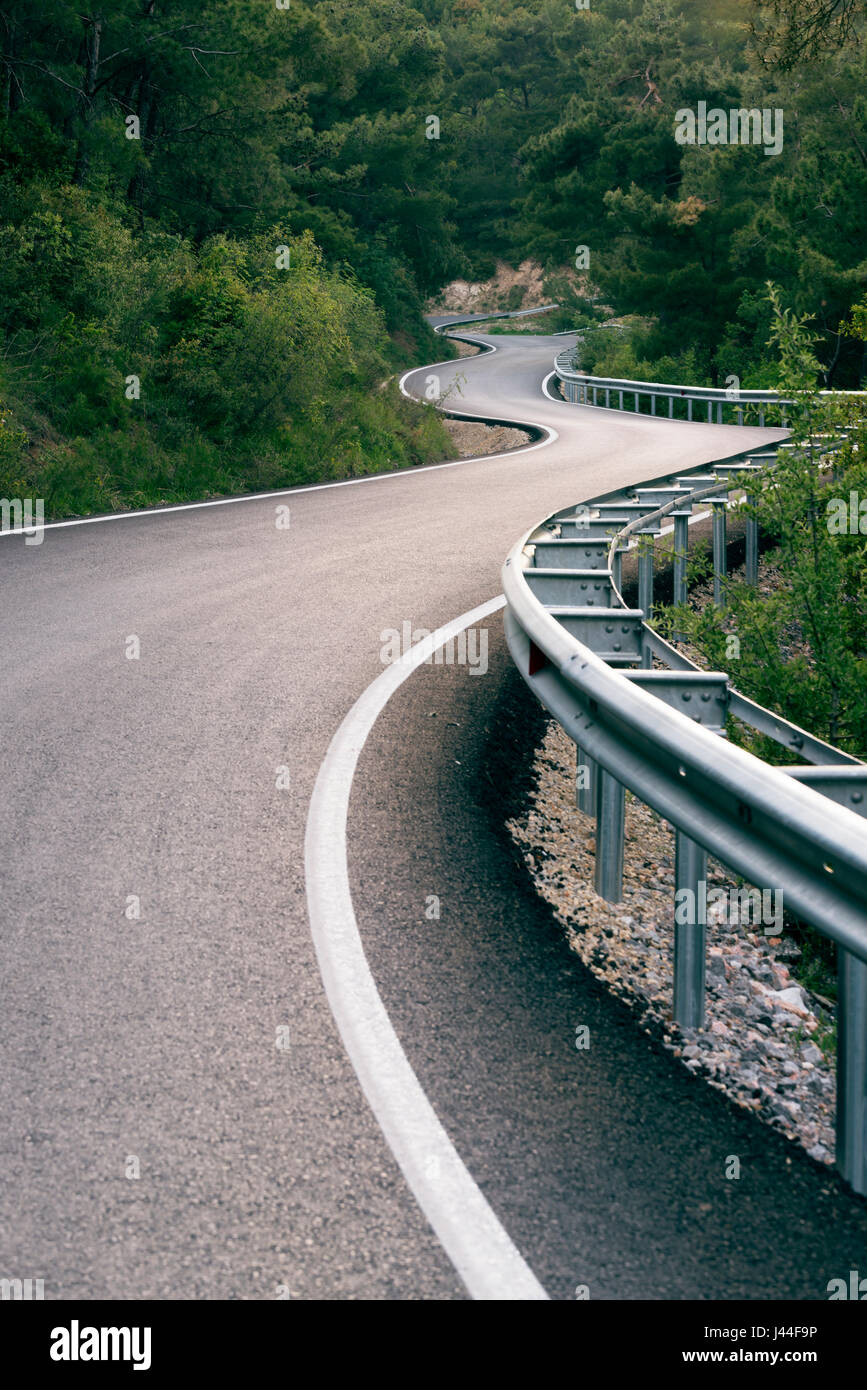 A forma di S nuova strada nella foresta. Foto Stock