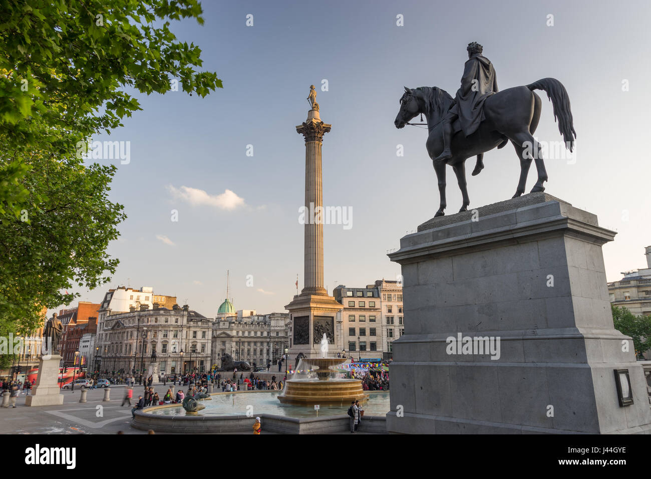 Vista esterna di Trafalgar Square di attrazione turistica di Londra, con vedute della fontana e la Colonna di Nelson durante la prima serata in primavera. Foto Stock