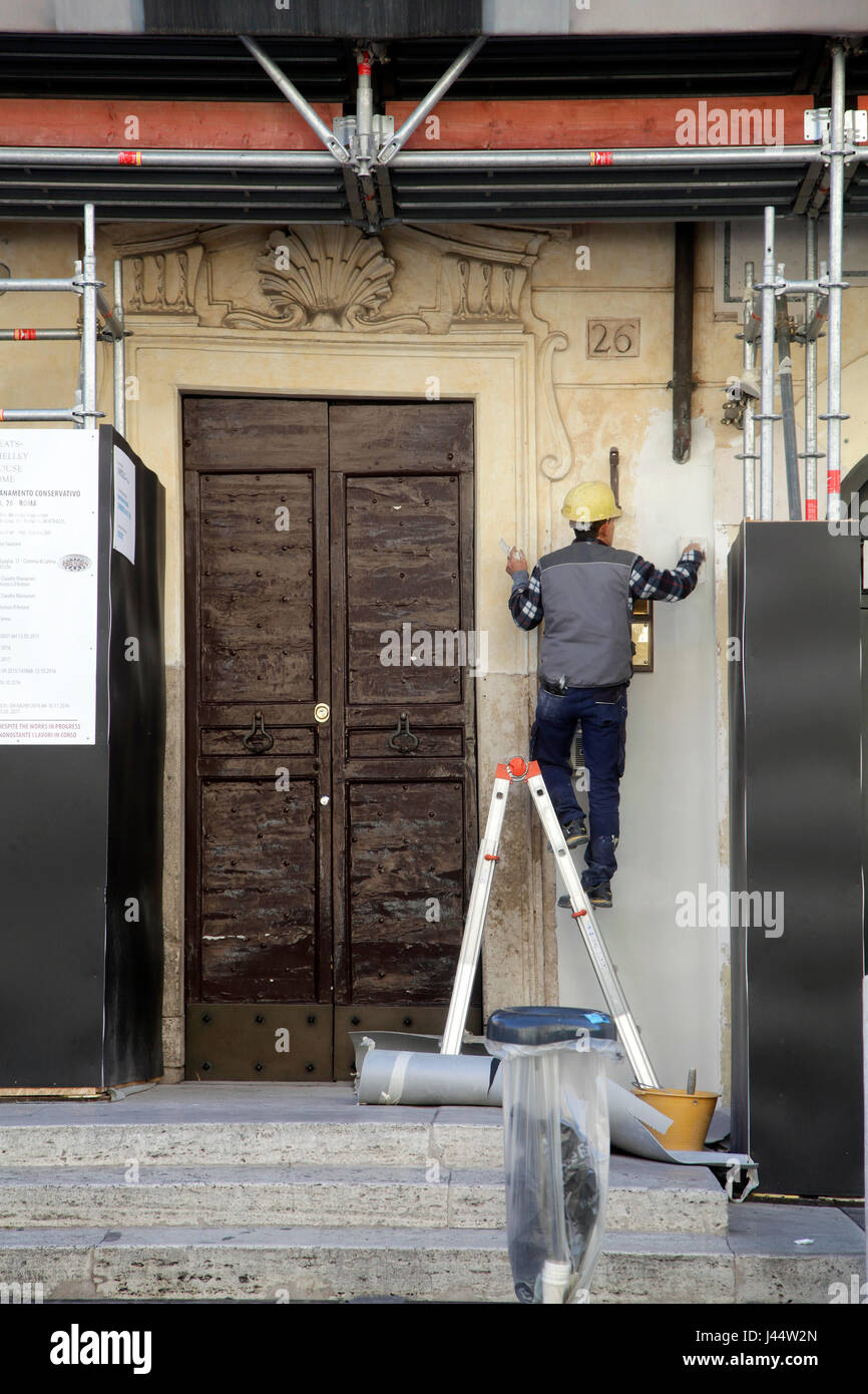 Muratore italiano la riparazione della parte esterna di una casa. Foto Stock