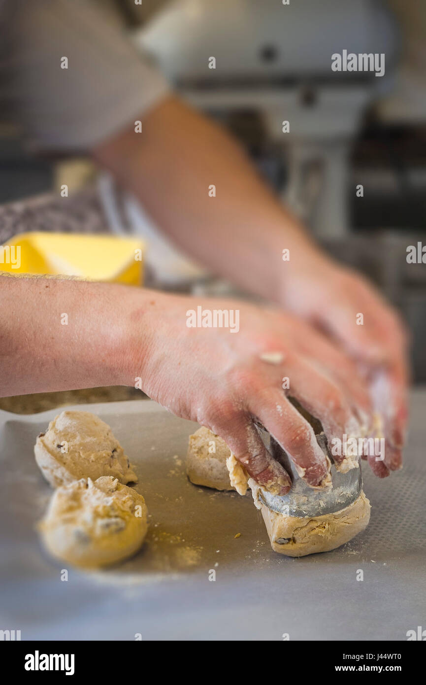 Un chef pasta da taglio per rendere scones cucina per la cottura di alimenti Ristorante di cottura per la preparazione di alimenti servizio alimentare industria di lavoro del lavoratore Foto Stock
