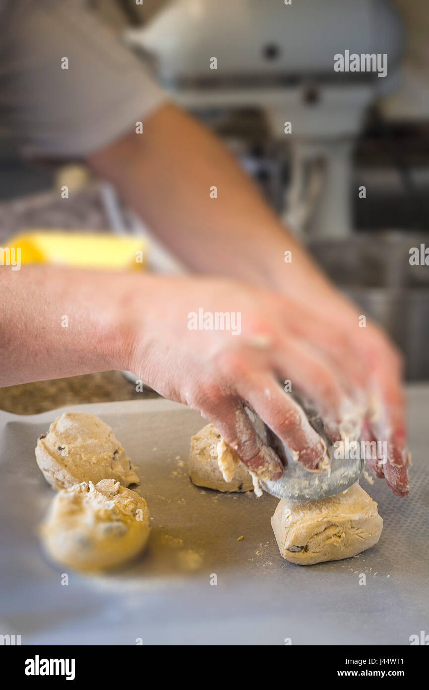 Un chef pasta da taglio per rendere scones cucina per la cottura di alimenti Ristorante di cottura per la preparazione di alimenti servizio alimentare industria di lavoro del lavoratore Foto Stock